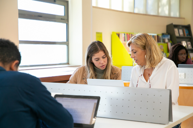Teacher researching housing grants with student — planning early for available incentives. Teacher researching housing grants with student — planning early for available incentives.