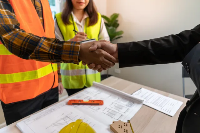 Builder reviewing construction plans and project finance